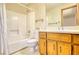 Bathroom featuring shower-tub combo, wallpaper, wood vanity, and ample counter space at 380 Hidden Valley Sw Dr, Conyers, GA 30094