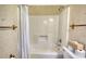 Bathroom featuring a white shower-tub combo, floral wallpaper, and vintage towel rack at 380 Hidden Valley Sw Dr, Conyers, GA 30094