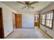 Spacious carpeted bedroom featuring paneled doors, large windows, and ceiling fan at 380 Hidden Valley Sw Dr, Conyers, GA 30094