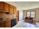 Kitchen features wood cabinets, black dishwasher, a window and access to a dining area at 380 Hidden Valley Sw Dr, Conyers, GA 30094