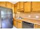 Traditional kitchen with wooden cabinets, double sinks, dishwasher, and refrigerator at 380 Hidden Valley Sw Dr, Conyers, GA 30094