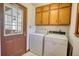 Functional laundry room featuring a washer, a dryer, and upper cabinets for storage at 380 Hidden Valley Sw Dr, Conyers, GA 30094