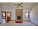 Open living room with brick fireplace, neutral carpet, and a ceiling fan for comfort at 380 Hidden Valley Sw Dr, Conyers, GA 30094