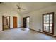 Inviting living room with neutral carpet, a vaulted ceiling, ceiling fan, and a door to the porch at 380 Hidden Valley Sw Dr, Conyers, GA 30094