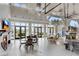 Bright clubhouse area featuring a fireplace, multiple tables, and a full wall of windows with views of the community at 708 Chipping Sparrow St, Canton, GA 30115