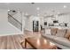 Open-concept living area with a staircase, hardwood floors, and a view into a modern kitchen at 708 Chipping Sparrow St, Canton, GA 30115