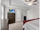 View of main bedroom featuring a tray ceiling, TV, and an ensuite door at 708 Chipping Sparrow St, Canton, GA 30115