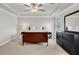 Bright main bedroom with a ceiling fan, tray ceiling, and large dresser with mirror at 708 Chipping Sparrow St, Canton, GA 30115