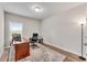 A well-lit home office with a large desk, ergonomic chair, and hardwood floors at 708 Chipping Sparrow St, Canton, GA 30115