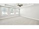 Spacious bedroom with plush carpeting, tray ceiling with ceiling fan, and abundant natural light at 104 Briargate Dr, Johns Creek, GA 30097