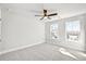 Bright bedroom featuring a ceiling fan, plush carpet, and two large windows offering plenty of natural light at 104 Briargate Dr, Johns Creek, GA 30097