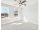 This bedroom features a ceiling fan, plush carpet, and two large windows offering plenty of natural light at 104 Briargate Dr, Johns Creek, GA 30097