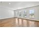 Sun-drenched living room featuring gleaming hardwood floors and multiple windows letting in abundant natural light at 104 Briargate Dr, Johns Creek, GA 30097