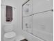 Clean bathroom featuring a bathtub with shower and sliding glass door, toilet, towel rack, and tiled walls at 1363 Sheffield Glen Way, Atlanta, GA 30329