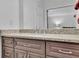 Close-up view of a bathroom vanity featuring a granite countertop and wooden cabinets at 1363 Sheffield Glen Way, Atlanta, GA 30329