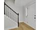 Bright foyer with hardwood floors, black staircase, and white door leading to living space at 1363 Sheffield Glen Way, Atlanta, GA 30329