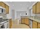 Modern kitchen with stainless steel appliances and light wood cabinets next to living room at 1363 Sheffield Glen Way, Atlanta, GA 30329