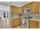 Bright kitchen featuring stainless steel appliances, stone countertops and light wood cabinets at 1363 Sheffield Glen Way, Atlanta, GA 30329