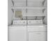 Laundry room features a washer and dryer and overhead shelving for storage at 1363 Sheffield Glen Way, Atlanta, GA 30329
