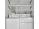 Convenient laundry room with shelving and a side-by-side washer and dryer at 1363 Sheffield Glen Way, Atlanta, GA 30329