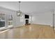 Bright open living room with wood floors, a fireplace, a TV, and a sliding door at 1363 Sheffield Glen Way, Atlanta, GA 30329