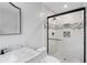 Modern bathroom featuring marble countertop, sleek black faucet, and tiled walk-in shower with shower head at 1752 Atherton Dr, Decatur, GA 30035