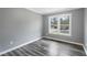 Bright bedroom with modern grey walls and grey wood flooring and a large window at 1752 Atherton Dr, Decatur, GA 30035