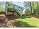 Spacious backyard with deck, walkout basement, lush lawn, and beautiful, mature trees at 2731 Old Coach Rd, Duluth, GA 30096