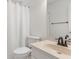 Neutral bathroom featuring a bathtub with white curtain, a toilet, sink, and large mirror at 2731 Old Coach Rd, Duluth, GA 30096