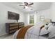 Bedroom featuring white walls, a ceiling fan, large window, wood dresser, and bed with white linens and gold blanket at 2731 Old Coach Rd, Duluth, GA 30096