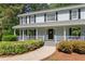 Inviting front porch with chairs, hanging ferns, and a beautifully landscaped walkway at 2731 Old Coach Rd, Duluth, GA 30096