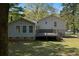 Backyard view of the house featuring a deck, fenced yard, and mature trees at 8876 Ashwood Dr, Riverdale, GA 30274
