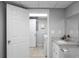 Bathroom featuring a granite countertop, sink, and white cabinets, and access to laundry room at 8876 Ashwood Dr, Riverdale, GA 30274