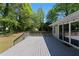 Gray wooden deck with railing surrounded by lush green trees, providing a private outdoor space at 8876 Ashwood Dr, Riverdale, GA 30274