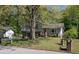 Split-level home with stone accents, a well-maintained lawn, and mature trees at 8876 Ashwood Dr, Riverdale, GA 30274
