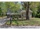 Charming split-level home featuring stone accents, a well-maintained lawn, and a mature shade tree at 8876 Ashwood Dr, Riverdale, GA 30274