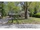 Charming split-level home featuring stone accents, a well-maintained lawn, and a mature shade tree at 8876 Ashwood Dr, Riverdale, GA 30274