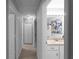 Hallway leading to bathroom vanity with granite counter and doors at 8876 Ashwood Dr, Riverdale, GA 30274
