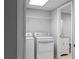 Laundry room featuring a washer, dryer, and tiled flooring, with a peek into the bathroom at 8876 Ashwood Dr, Riverdale, GA 30274