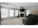 Living room featuring a stone fireplace, neutral carpeting, and lots of natural light at 8876 Ashwood Dr, Riverdale, GA 30274