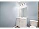 Well-lit powder room features a modern vanity with a framed mirror and a standard toilet at 998 Sisley Trl, White, GA 30184