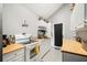 Galley kitchen with white cabinets, wood countertops, and modern appliances at 998 Sisley Trl, White, GA 30184