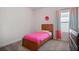 Comfortable bedroom with soft gray carpet and a bed dressed in a pink bedspread and matching drapes at 1151 Wisteria Sw Dr, Mableton, GA 30126