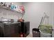 Laundry room with modern, dark washer and dryer and shelf for storage at 1151 Wisteria Sw Dr, Mableton, GA 30126