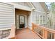 Welcoming entryway with a covered porch featuring a wooden ramp, glass-paneled front door, and stone accents at 2417 Tree Arbor Way, Marietta, GA 30064