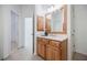 Bathroom with wooden vanity, neutral tile, and doorway leading to another room at 5210 Davenport Pl, Roswell, GA 30075