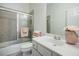 Bathroom featuring a tub/shower with glass doors, a vanity, and decorative flowers at 5210 Davenport Pl, Roswell, GA 30075