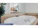 Bright bathroom features a large soaking tub with tile surround and natural light at 5210 Davenport Pl, Roswell, GA 30075
