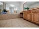 Bathroom with neutral tile, jacuzzi tub, and wood cabinets at 5210 Davenport Pl, Roswell, GA 30075