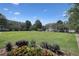 Beautiful grassy lawn with manicured flower beds in front of condos under a blue sky at 5210 Davenport Pl, Roswell, GA 30075